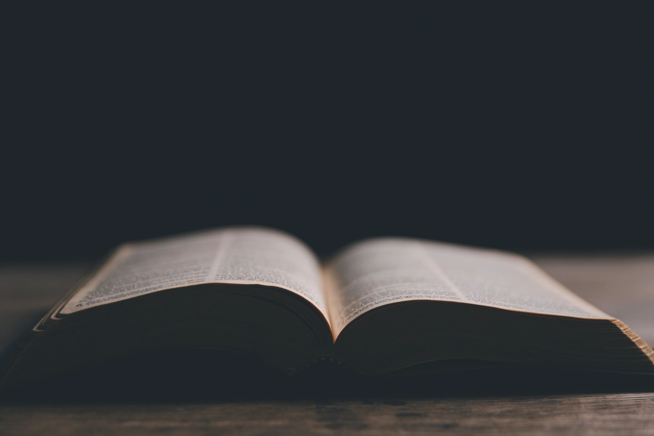 Open Bible with cross in the background